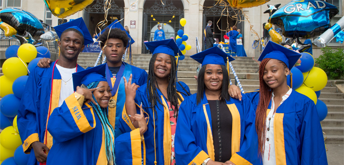 "JSI graduates standing in graduation gear"